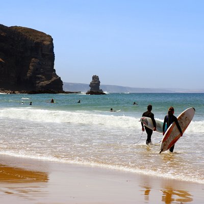 surfers ready to enter the sea in arrifana beach, algarve portugal 